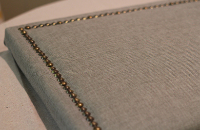 Looking to change up your headboard? Take a look at this awesome DIY Upholstered Headboard with Nailhead Trim! UpcycledTreasures.com