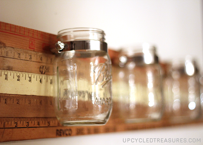 Looking for a creative storage solution? Check out how to create a mason jar wall storage using vintage yardsticks! UpcycledTreasures.com