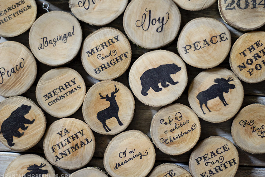 See how easy it is to create these rustic cabin Inspired Christmas ornaments from wood slices. Plus Download the FREE printable designs to use on your own holiday ornaments. mountainmodernlife.com