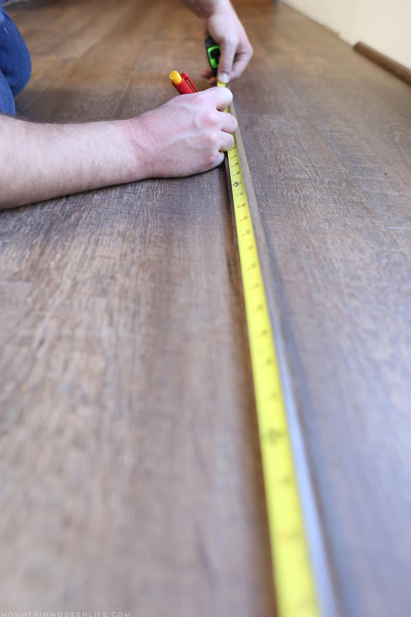 Measuring our quarter round trim for flooring installation | MountainModernLife.com