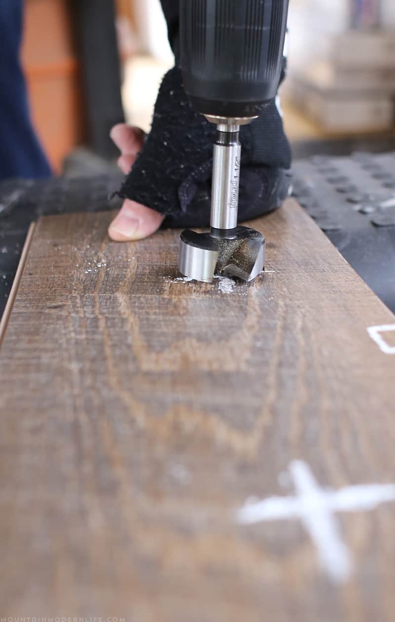 Creating hole in flooring with Forstner bit to create space for bolts | MountainModernLife.com
