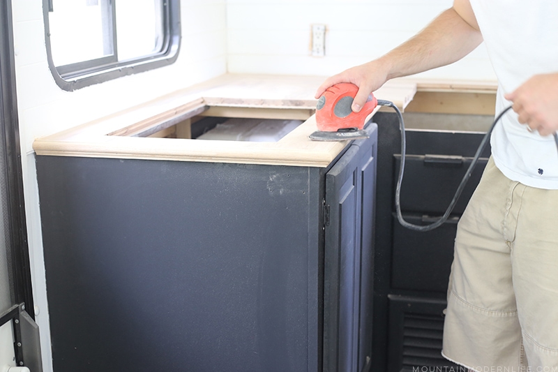 Looking for an affordable way to update your kitchen counters? Check out this post on how to Create Wood Counters from Flooring in a RV! MountainModernLife.com