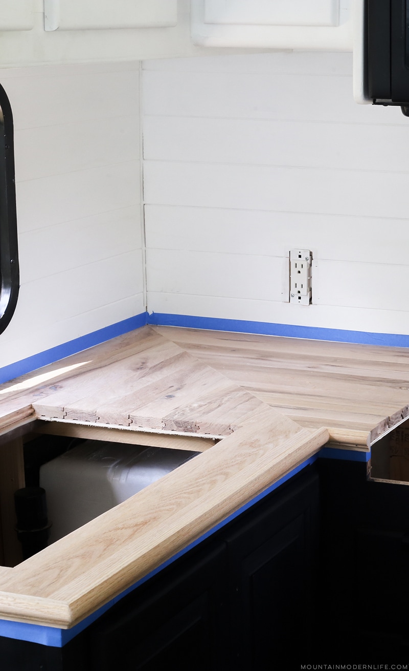 Looking for an affordable way to update your kitchen counters? Check out this post on how to Create Wood Counters from Flooring in a RV! MountainModernLife.com