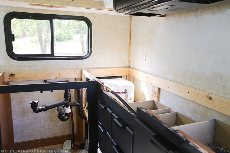 Easily install a wood planked kitchen backsplash in a RV! This is the perfect way to add rustic modern or farmhouse style to your tiny home on wheels!