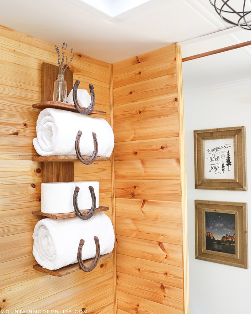 Organize your bathroom with this rustic bathroom shelf that uses horseshoes to keep towels and toiletries in place! 