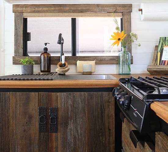 Thinking about renovating your camper? Come see how we used reclaimed wood to create a rustic modern RV kitchen! MountainModernLife.com