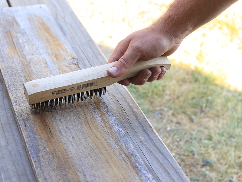 Cleaning reclaimed wood with a wire brush | MountainModernLife.com