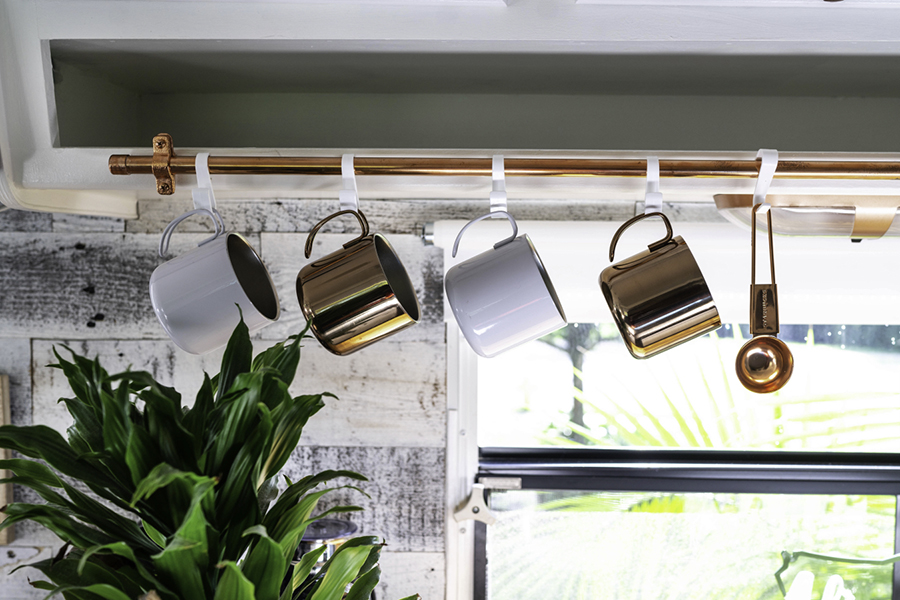 mugs hanging on copper pipe