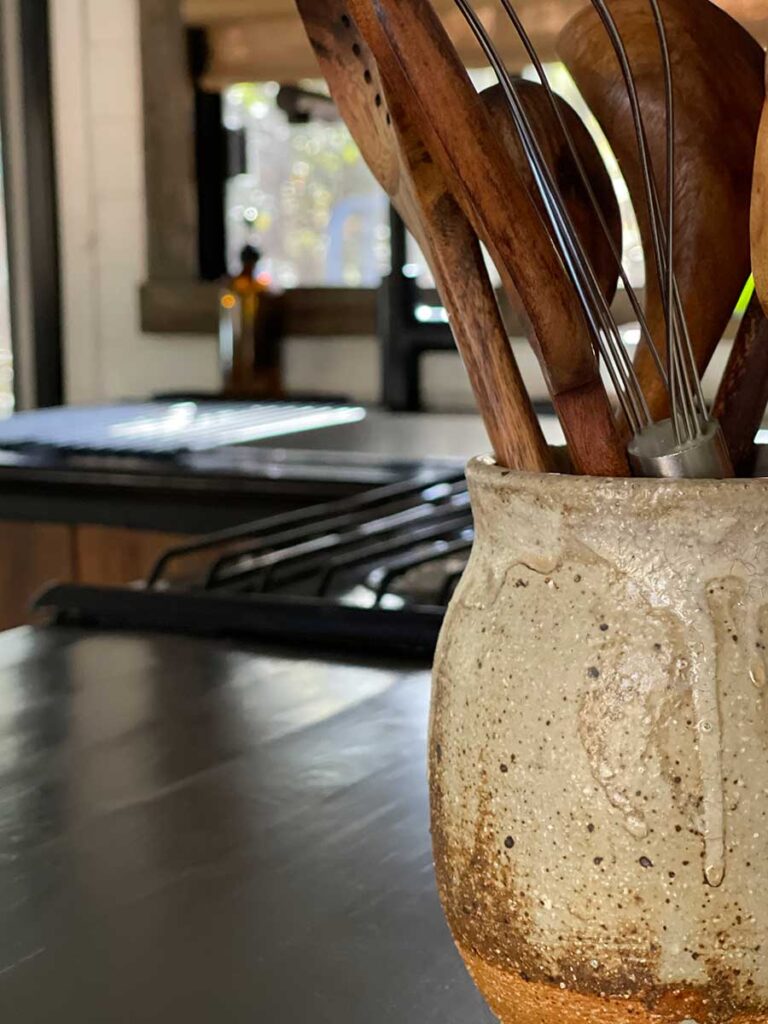 ceramic pot with wooden kitchen utensils