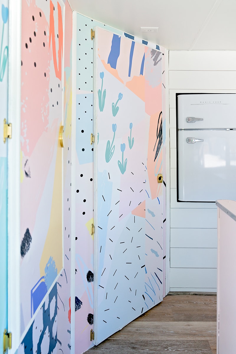 The playful interior of this vintage camper renovation was inspired by abstract pop wallpaper